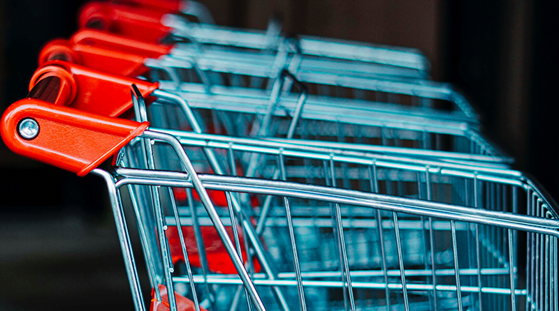 Shopping carts lined up on a black background representing automated shopping bots