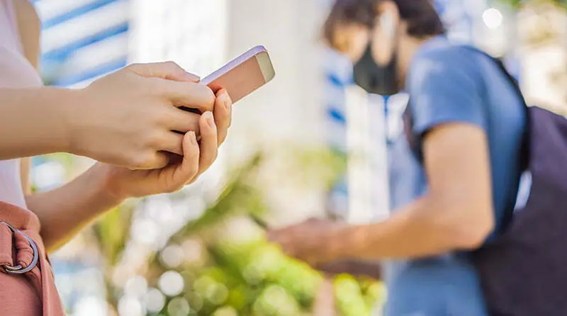 People looking at their cell phones representing exposure notification privacy