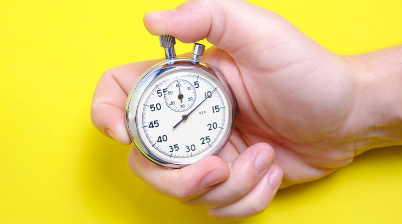 A hand holding a stopwatch representing block bots fast